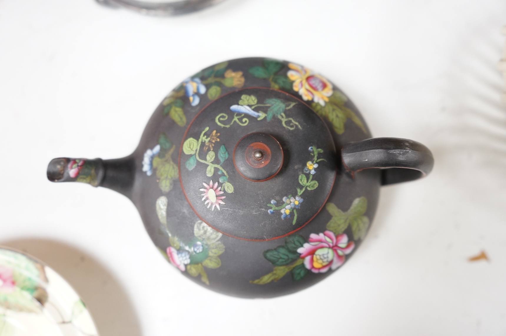 A collection of Wedgwood comprising basalt and jasper biscuit barrels, an enamelled basalt teapot, and a cover and creamware basket, largest 26cm high (4)